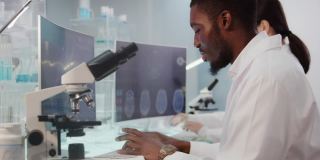 非洲和亚洲的科学家正在研究DNA样本。带有DNA序列和脑波扫描的电脑屏幕。专注于工作