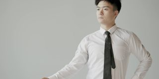 年轻的亚洲男性白领在办公室里锻炼身体。简单的办公室运动有助于恢复精力