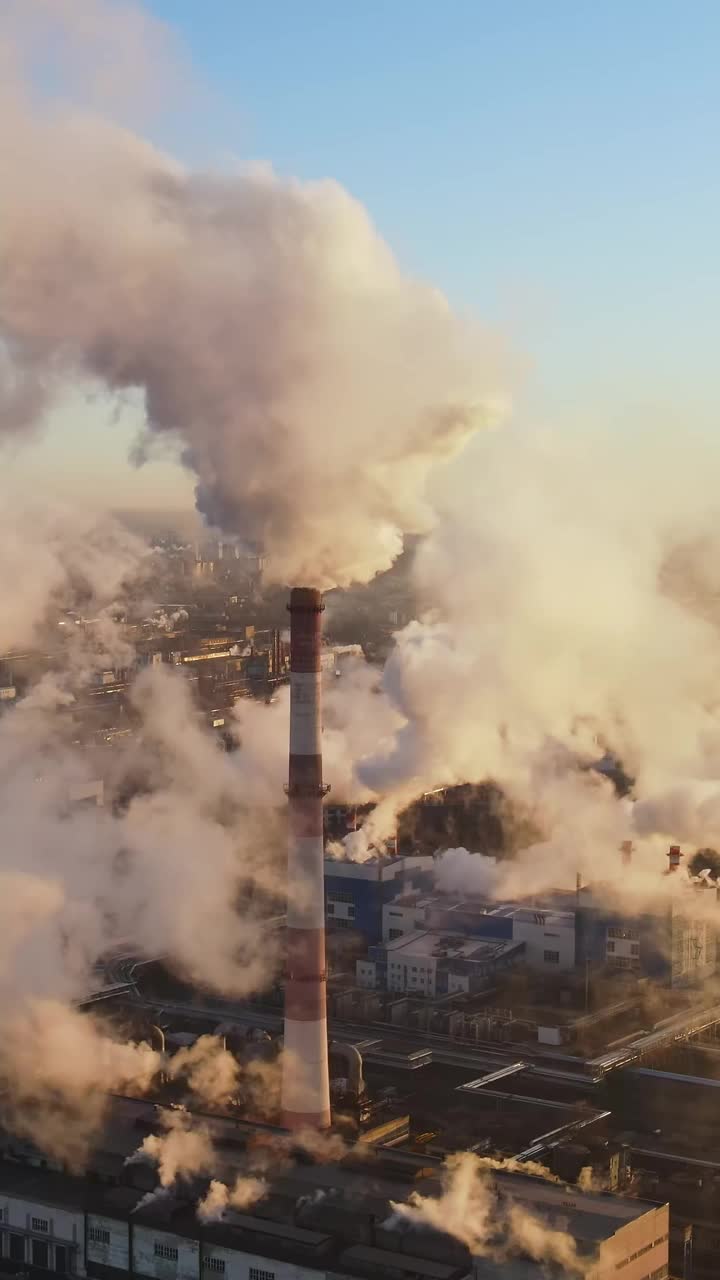 工业工厂在空气中排放气体，垂直录像。