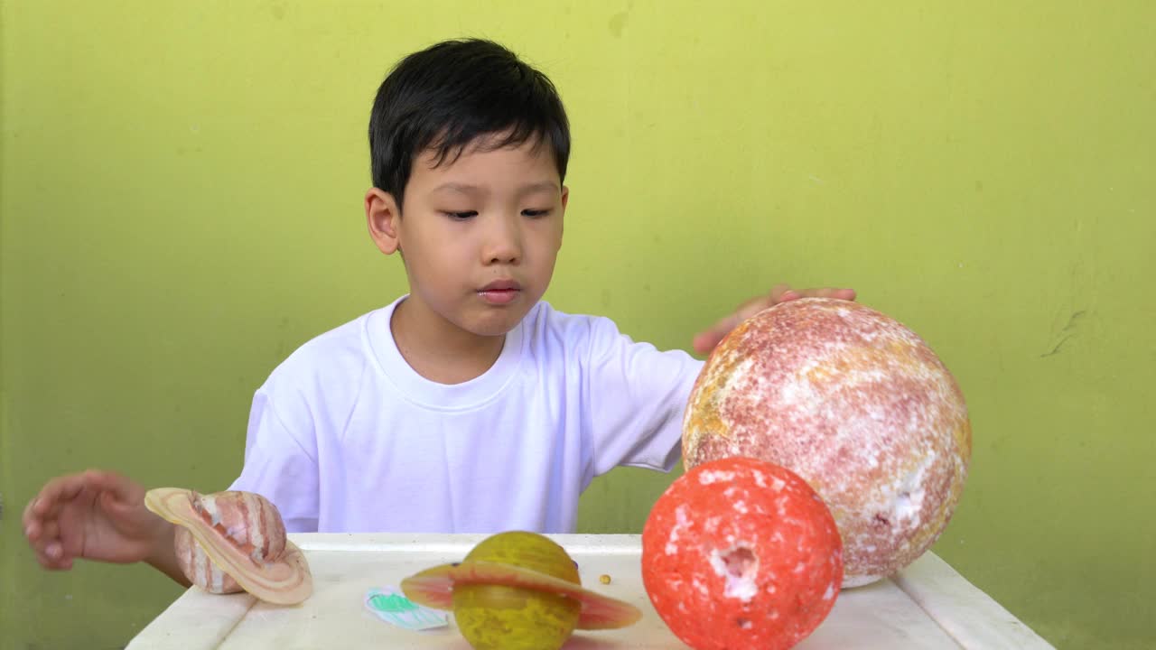亚洲男孩生活太阳能系统玩具，家庭学习设备，在新冠病毒或新冠病毒爆发后的新常态变化期间呆在家里