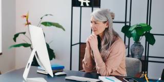高级商业女性被压力、焦虑搞糊涂了，在办公室的电脑前超负荷工作