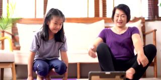 亚洲母亲和女儿在家里做瑜伽快乐