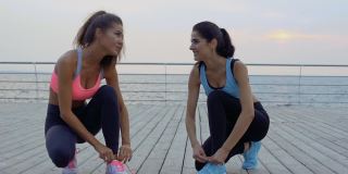 两名年轻的女运动员为跑步系鞋带