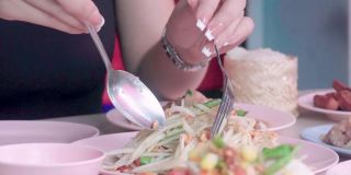 美女在餐馆里吃着木瓜沙拉或青Tam——泰国街头小吃