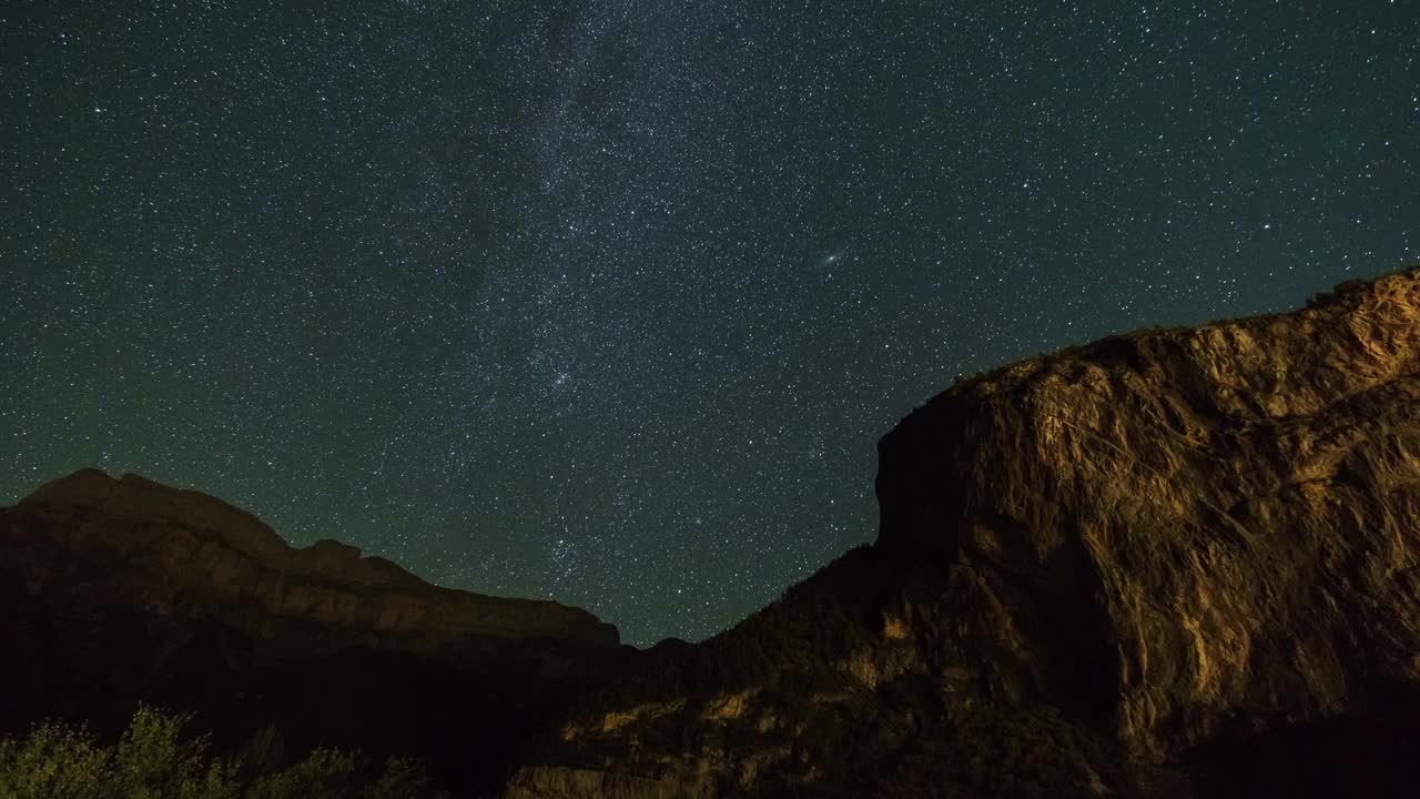 银河系和仙女座星系在夜空中移动，前景是岩石的形成，西班牙托拉