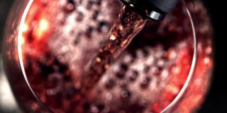超级慢动作红葡萄酒与气泡倒进玻璃杯。用高速摄像机以每秒1000帧的速度拍摄。