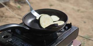 在煤气炉上煎茄子。烹饪