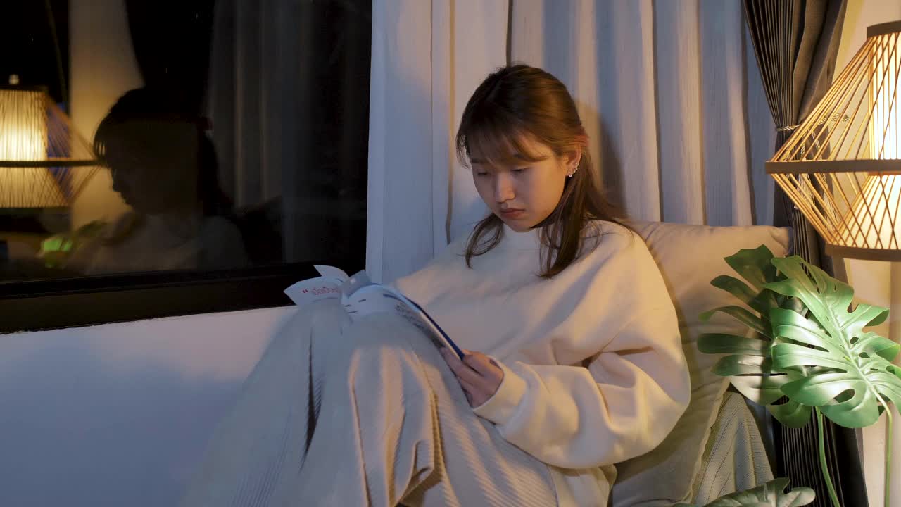 一个年轻的女人在晚上看书，压力很大