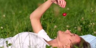 一颗红色的樱桃在一位女农民的手中
