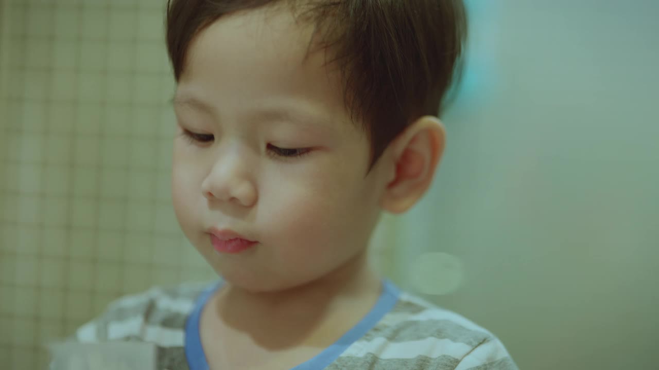 亚洲小孩，男孩，蹒跚学步的小孩在晚上洗澡的时候用儿童牙刷刷牙。
