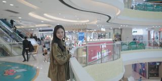 年轻美丽的中国女性正在购物，她们留着长长的棕色头发，对着镜头微笑着