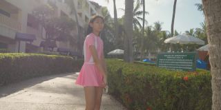 亚洲女孩穿着泳装，在酒店度假时走在去海滩的路上，生活方式的概念。