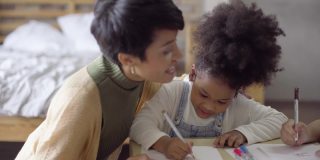 非洲裔美国少女在家里和亚裔妇女一起学习和学习家庭作业