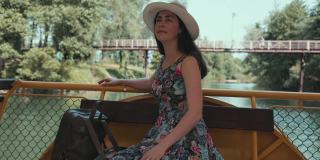 乘坐有轨电车游览。一位戴着草帽、穿着草裙的美丽年轻女子正坐在那里欣赏大自然。暑假的概念