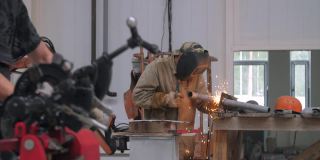 身穿防护服的工人在工厂焊接零件