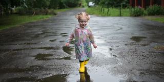 这个小女孩在更好的雨天跑步。童年好心情