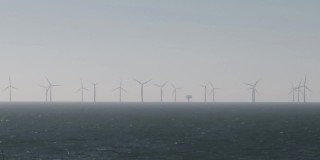 风筝冲浪前景与离岸炮舰和离岸风电场的遥远的观点。艾塞克斯海岸