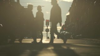 日落时人们穿过街道的慢镜头剪影。城市和城市生活理念视频素材模板下载