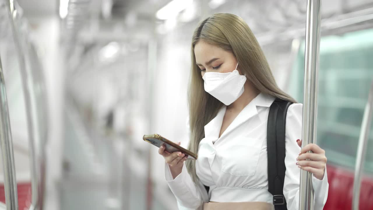 乘坐地铁时戴着智能手机的4K年轻女性
