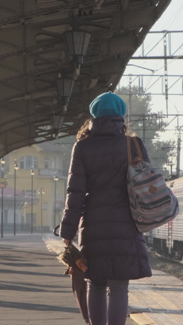 秋天，一个女人走在火车站台上