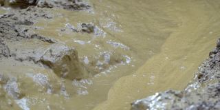 在洪水泛滥和春季大雨期间，肮脏的河水和淤泥的特写