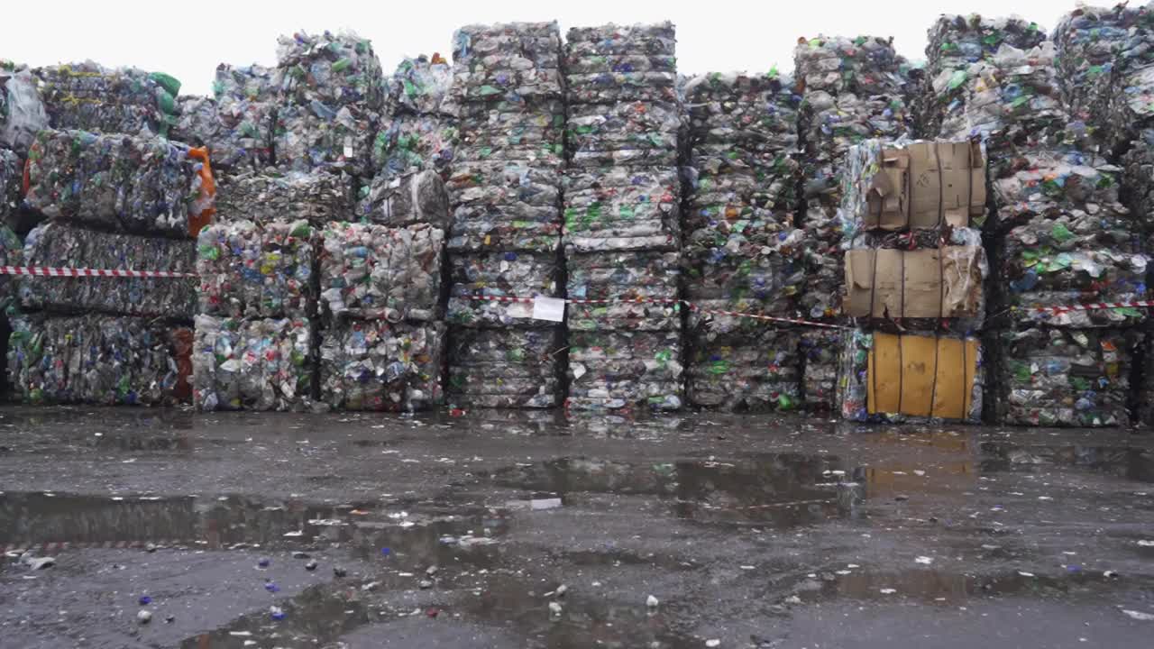 在废物回收厂为垃圾回收准备的一捆压过的塑料瓶。摄像机移到一边。污染问题。稳定的视频