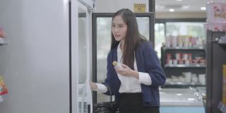 一名亚洲女商人身穿蓝色休闲装，正在一家杂货店购买商品和服务，然后在当地的一家泰国商店回家。
