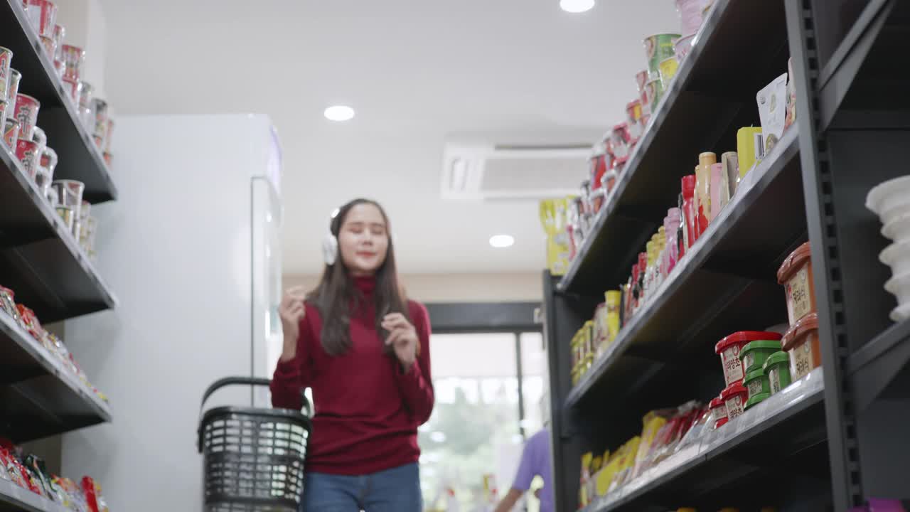 一名亚洲女商人身穿红色便装，正在一家杂货店购买商品和服务