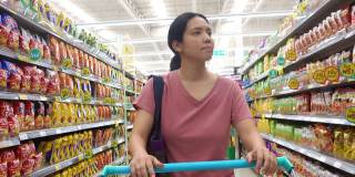 亚洲成熟女性在杂货店购物，用可重复使用的购物袋