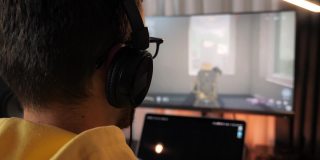 男玩家在功能强大的个人电脑上玩在线视频游戏。国务委员的游戏。年轻人沉迷于电子游戏，在电脑前浪费时间