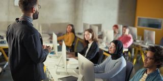 教师在大学教室里给多元化的多民族男女学生上课，学习计算机科学，商业关系或性别理论。讲师与学者分享知识。