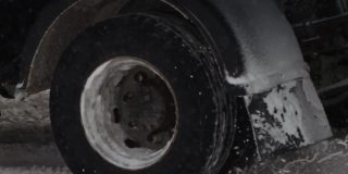 一辆卡车在冬天的雪地上行驶。用慢动作关闭车轮轮胎。交通状况不佳，暴风雪。危险之旅