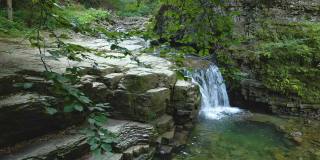 令人惊叹的风景，美丽的山河瀑布与白色泡沫水从岩石悬崖下降在夏季雨林。