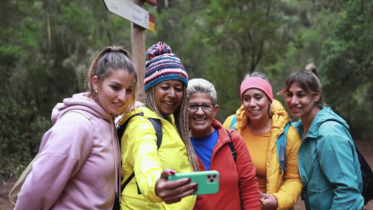 多代妇女在徒步旅行期间用手机进行视频通话