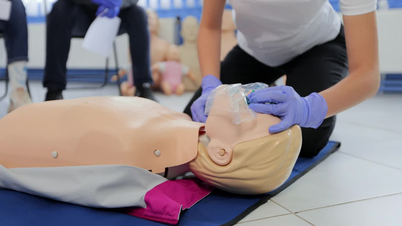 一名女子在急救课上用人体模型做心肺复苏。