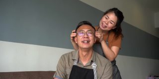 一个亚洲女人在家里给她的丈夫按摩