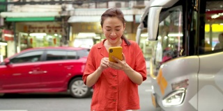 在泰国曼谷的夜市，4K亚洲女性正在使用智能手机旅行