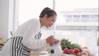 亚洲高级妇女准备自制水果冰沙与不同的口味，草莓，石榴，橘子和酸奶。健康的天然益生菌调味饮料，侧视视频素材模板下载