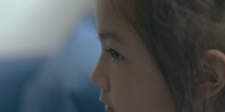 特写和侧视图与复制空间可爱的亚洲小女孩的脸，谁是向前看和坚定的情绪显示眼睛的细节为美丽的童年肖像与明亮的光。