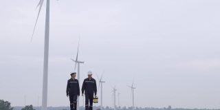 两名亚洲工程师统一检查工程师准备和进度检查风力涡轮机与安全在泰国风电场。