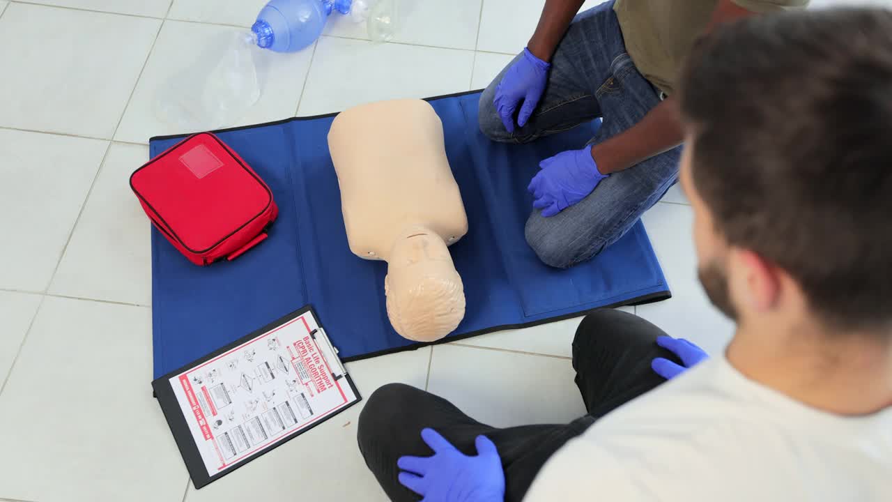 特写学生练习CPR胸部按压青少年假人。