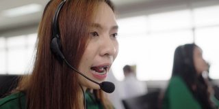 亚洲护士在呼叫中心办公室的电脑上对病人进行远程保健咨询。