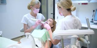 牙科医生，助理和病人用口腔内扫描仪扫描牙齿