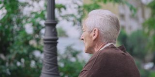 白发苍苍的老人坐在公园的长椅上，孤独的退休，悲伤的离去