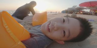 亚洲的孩子们微笑着在沙滩上玩沙子