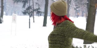 顽皮的红发女郎在雪地上打转