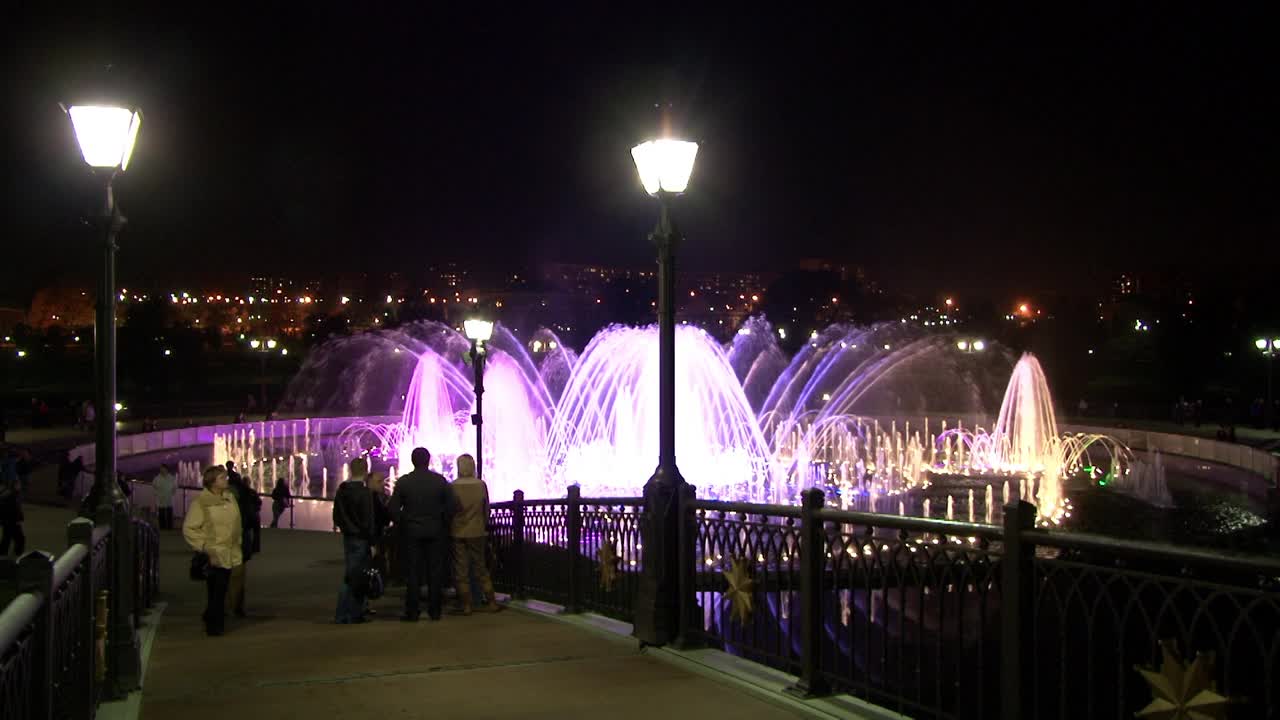 人们晚上在跳舞的喷泉附近散步。