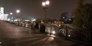 晚上，两个女孩走在父系桥上，来到基督救世主大教堂。