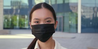亚洲女企业家在户外摘下防护口罩