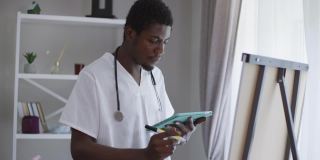 中镜头，聪明的非洲裔美国男性医生站在白板前，用记号笔书写。集中智慧的年轻人分析接种疫苗的副作用和效率。